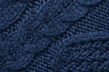 A dark blue piece of knitted fabric with an intricate cabled pattern.