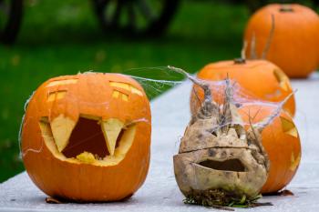 A small pumpkin carved into a Jack-o'-lantern sits alongside a carved turnip reminiscent of the old Irish tradition.
